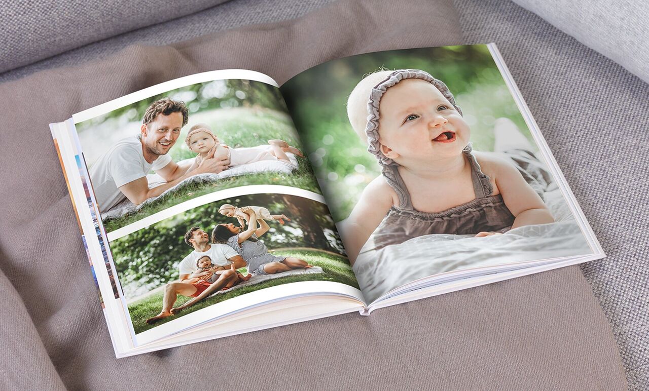 Een geopend fotoboek toont liefdevolle familiemomenten buiten. Pagina's met blije mensen en kinderen.