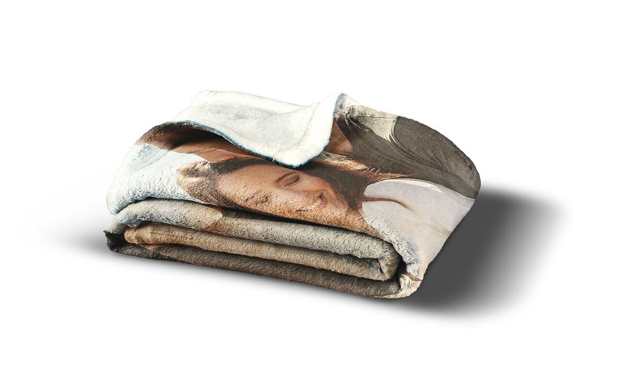 Een gevouwen, gepersonaliseerd deken met een lach. Het toont een gelukkige vrouw met lang haar en een liefdevolle uitstraling. Ideaal voor gezellige momenten.