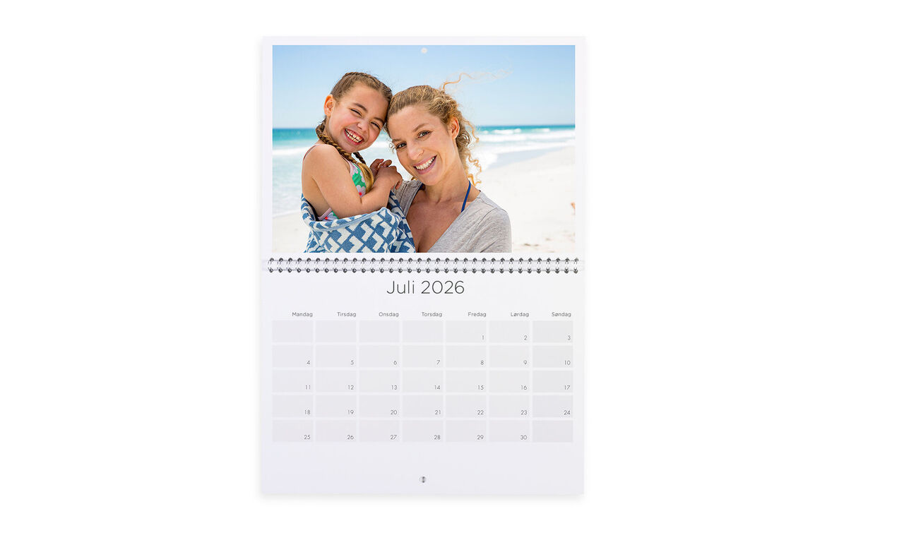Een kleurrijke fotokalender voor juli 2025 met een vrolijke moeder en haar kind op het strand.