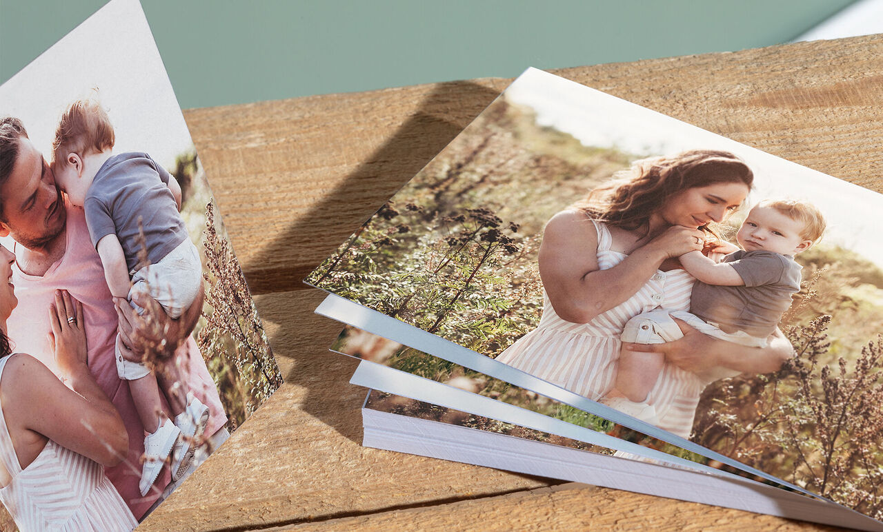 Een koppel ontdekt een CEWE Fotoboek op een houten oppervlak buiten.