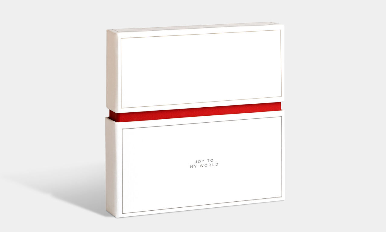 Cadeauverpakking in wit met rode strik en de tekst 'Joy to my world'