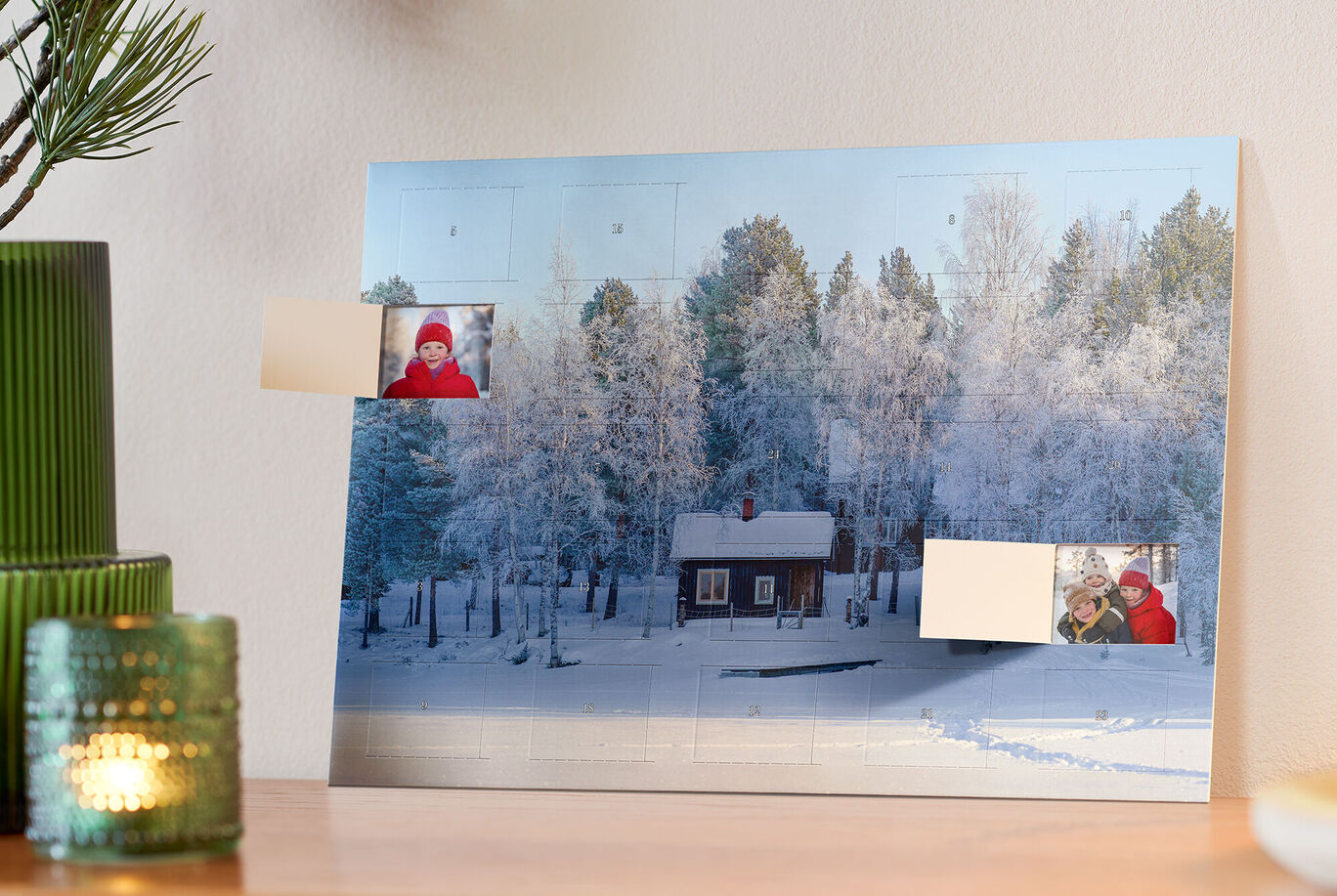 Een prachtige sneeuwachtergrond met een klein rood houten huisje omgeven door besneeuwde bomen. Enkele foto's zijn geplaatst.
