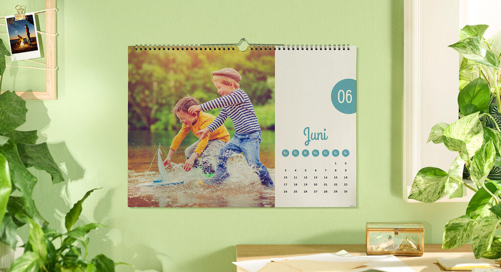 Een kleurrijke kalender toont twee spelende kinderen in water op een zonnige dag. Het is januari.
