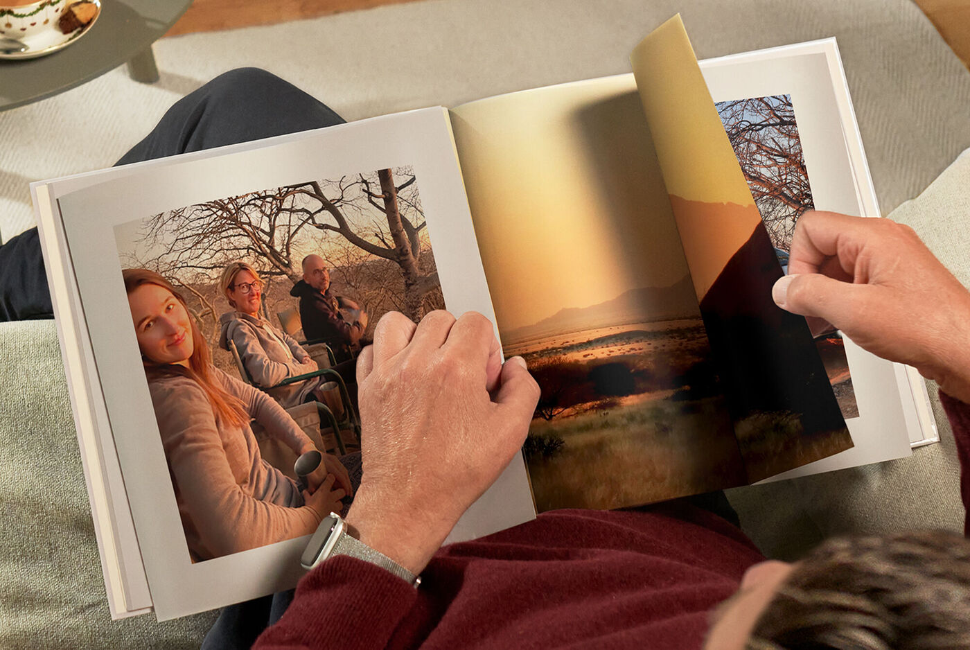Iemand bladert door een CEWE FOTOVOEK met landschappen en buitenfoto's.
