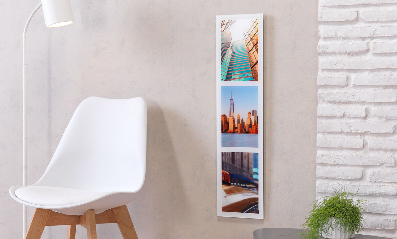 Heldere, moderne kamer met drie foto's aan de muur.