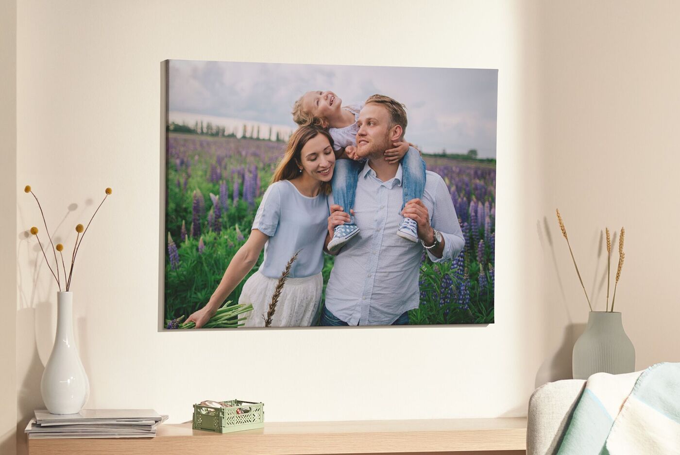 Er hangt een canvas wanddecoratie aan de muur met een wandelende moeder en vader met een kind op zijn nek.