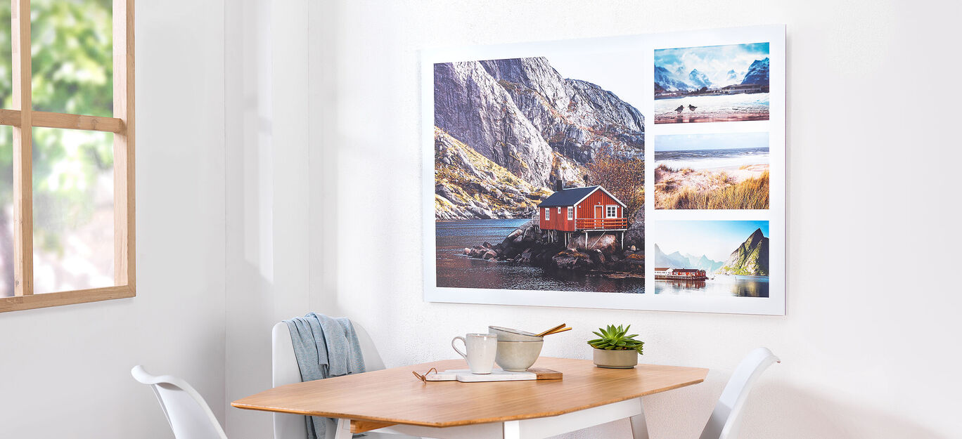 Wanddecor met rode vakantiewoning en natuurfoto’s in de woonkamer.