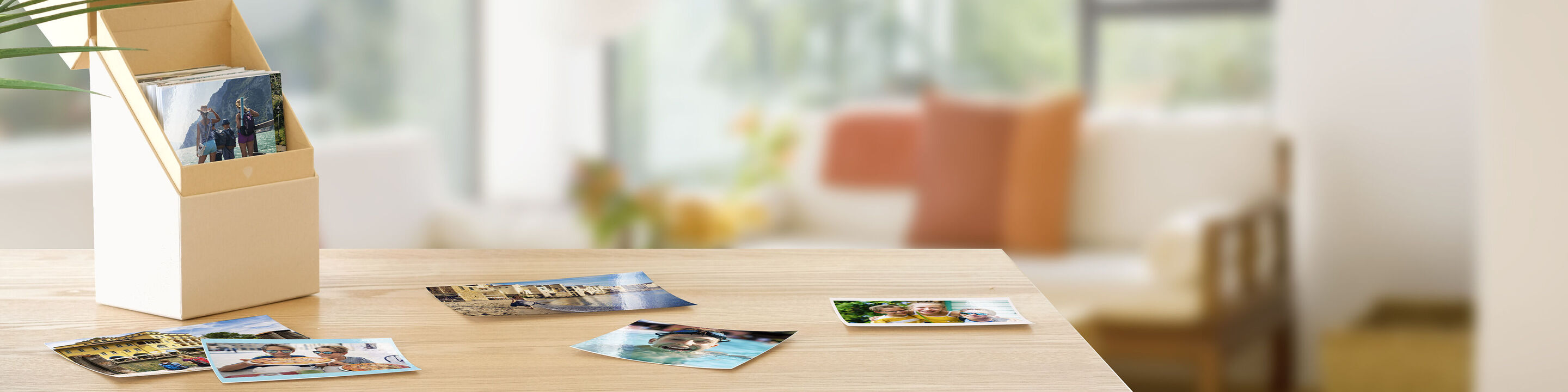 Een houten standaard met foto's en kaarten op een tafel. Achtergrond met een kamer met bank en planten.