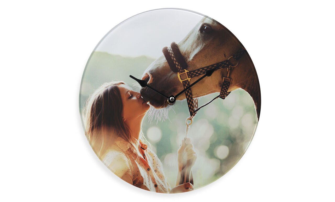 Een vrouw kust liefdevol een paard op de neus in een prachtige natuurlijke omgeving.