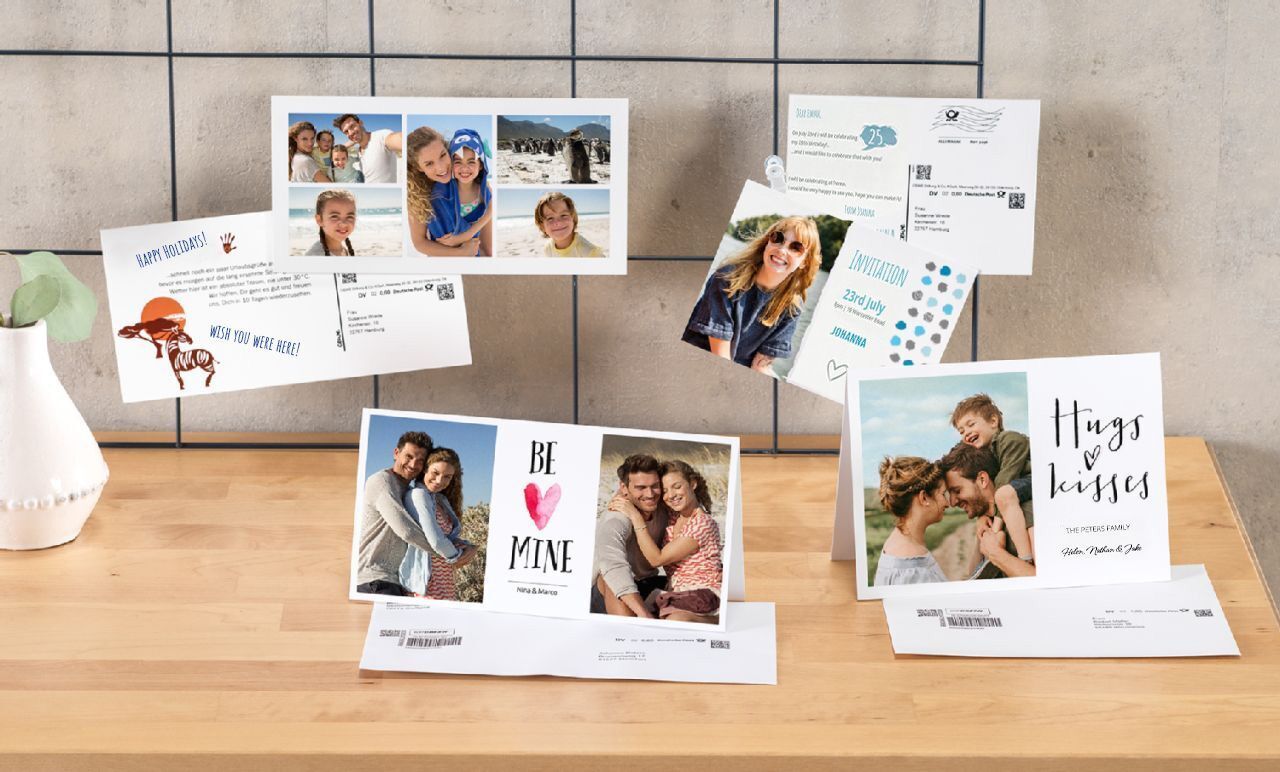 Verschillende creatieve wenskaarten staan op een houten stapel, met liefdevolle foto's en berichten.