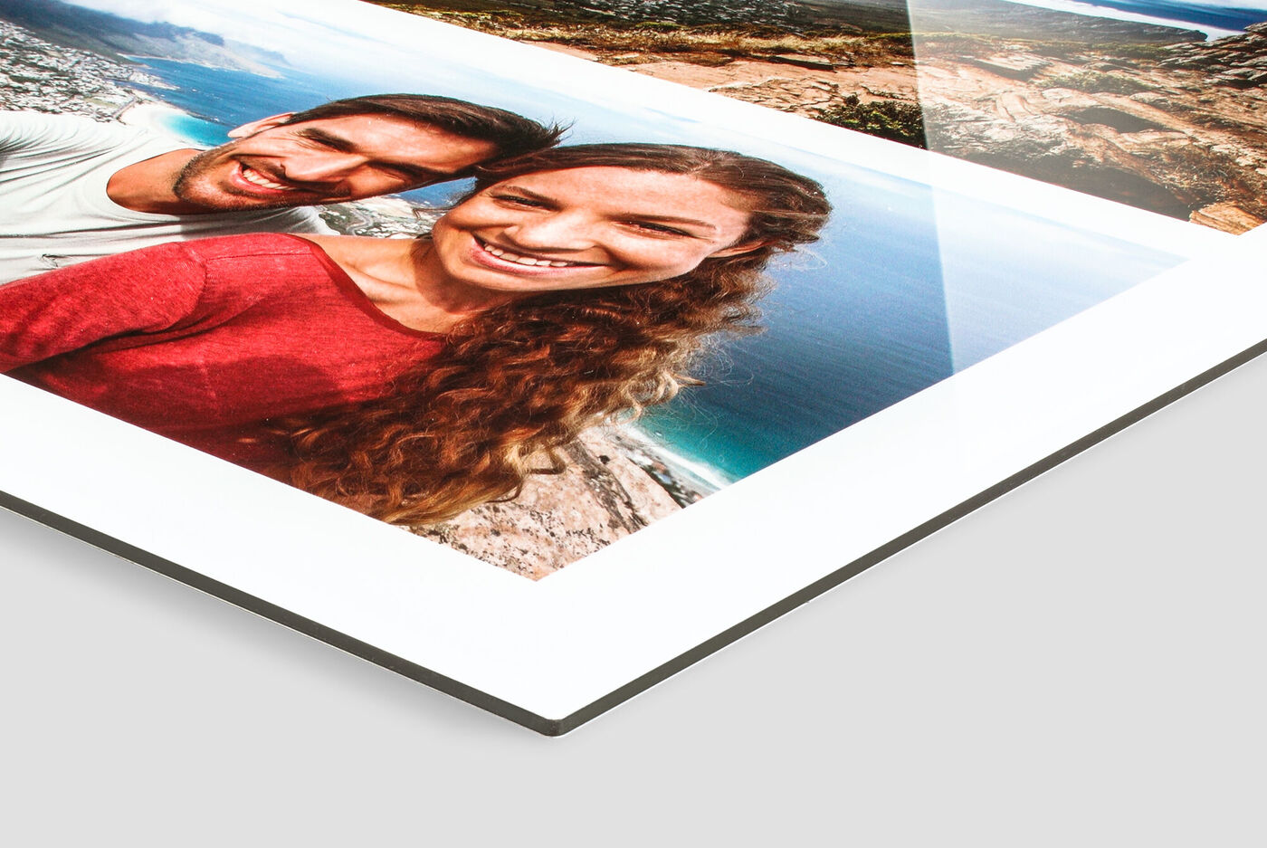 Verliefd stel houdt een CEWE Fotoboek met vakantieherinneringen vast.