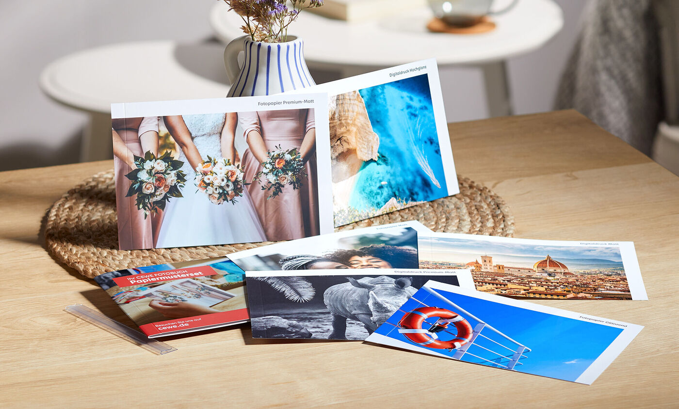 Mooie foto's en wenskaarten op een houten tafel, omringd door een vaas met droogbloemen.