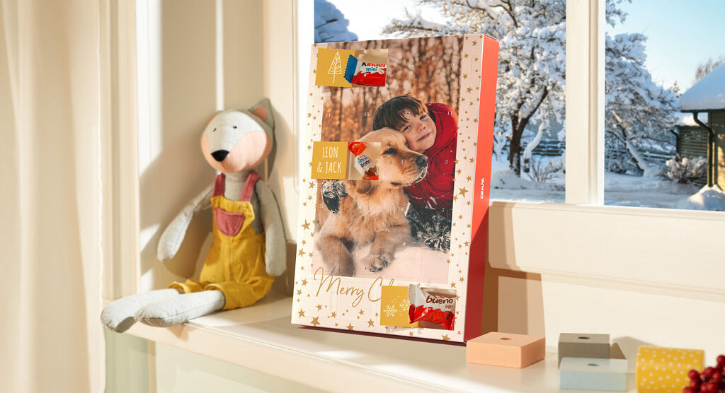 Een liefdevol ontworpen CEWE fotoboek naast een knuffeldier op een vensterbank met winteruitzicht.