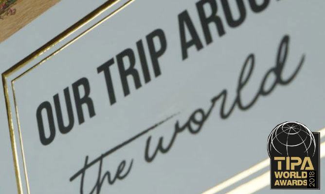 Detailopname van een lijst met de tekst "OUR TRIP AROUND the world" en het TIPA World Awards-logo