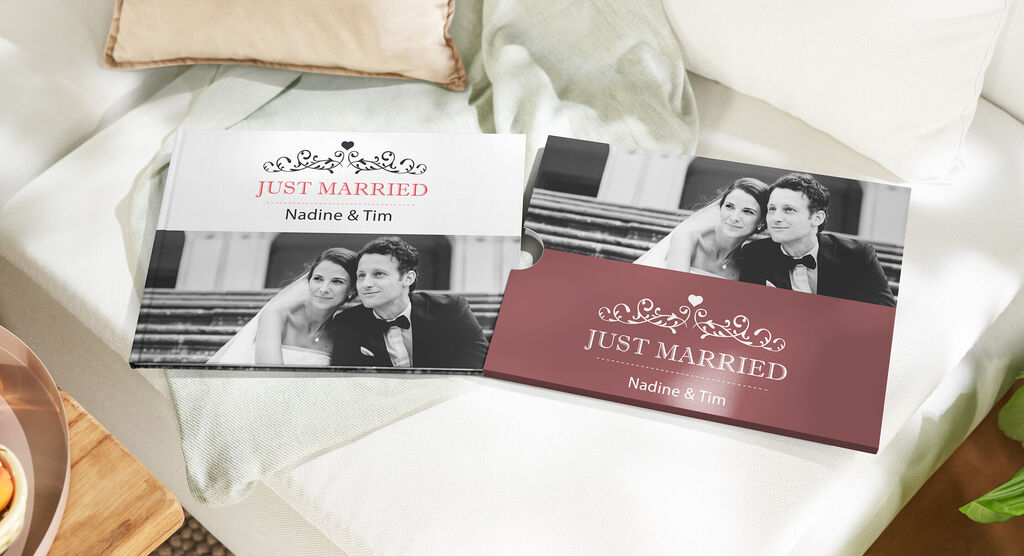 Twee trouwalbums met de titel 'Just Married' liggen op een bank.