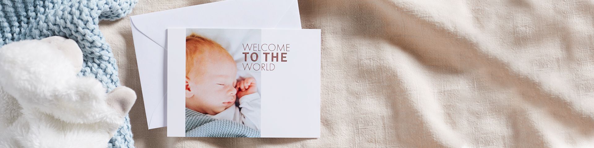 Een schattige baby slaapt vredig op een lichte deken, omringd door een elegant ontworpen set wenskaarten.