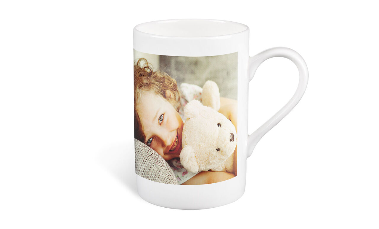 Een mok met een foto en een knuffelbeer.