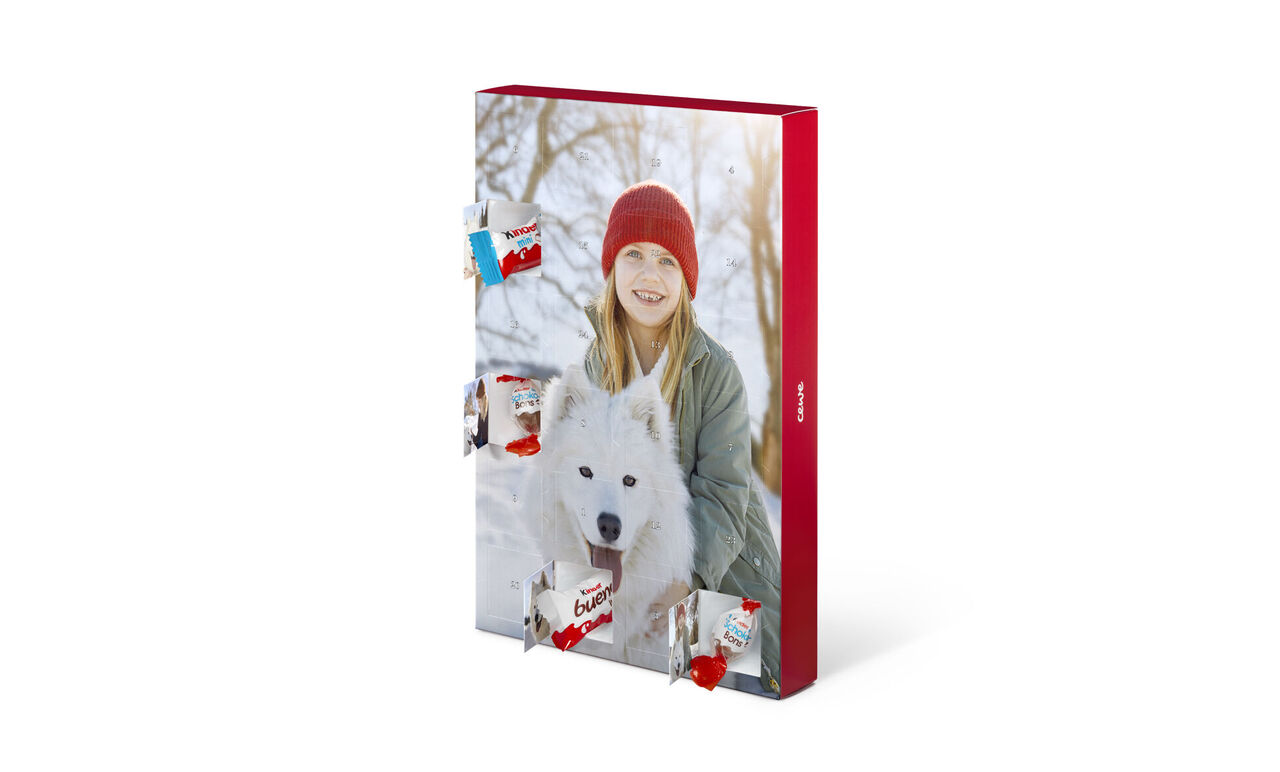 Een jonge vrouw met een witte hond in haar armen. Ze staat in een besneeuwd landschap met een rode hoed op. Vage bomen op de achtergrond.