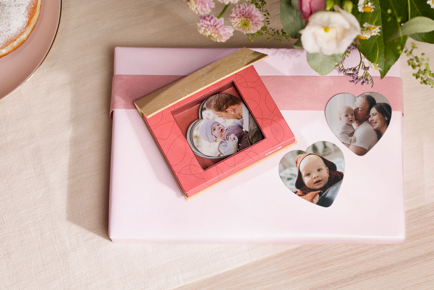 Cadeau verpakt met fotokaarten in hartvorm en een doos met foto's.