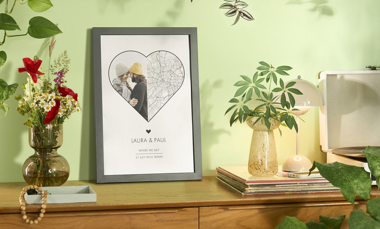 Een lief wall-art in hartvorm met de namen Laura en Paul. Planten en decor op de achtergrond.