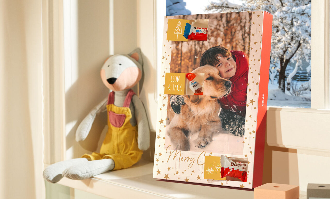 Een adventskalender op een vensterbank, omringd door sfeervolle decoratie. Met zichtbare lekkernijen binnenin.