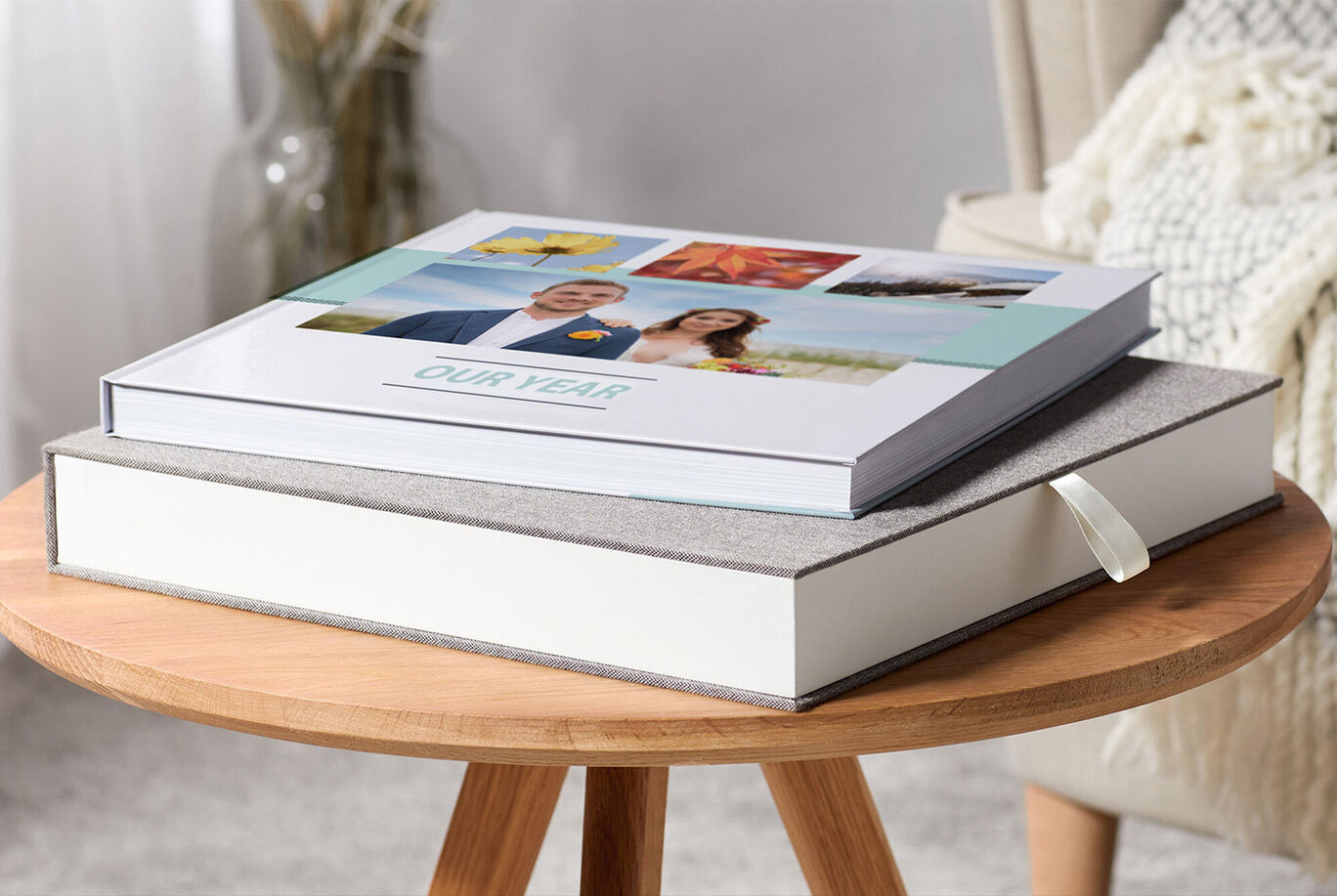 Twee CEWE FOTBOEKEN op een tafel. Eén boek heeft een omslag met foto's, het andere is eenvoudig en decoratief.