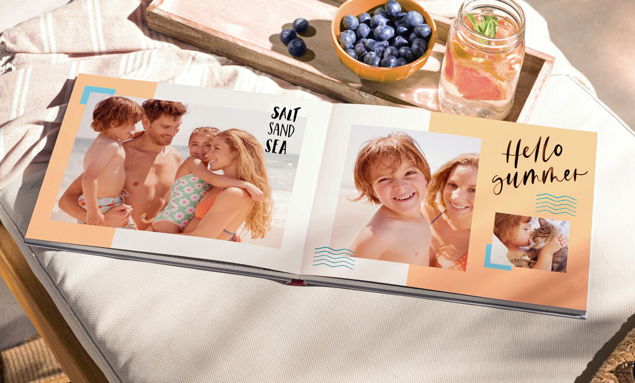 Een open fotoboek met zomerbeelden op het strand, omringd door verse levensmiddelen.
