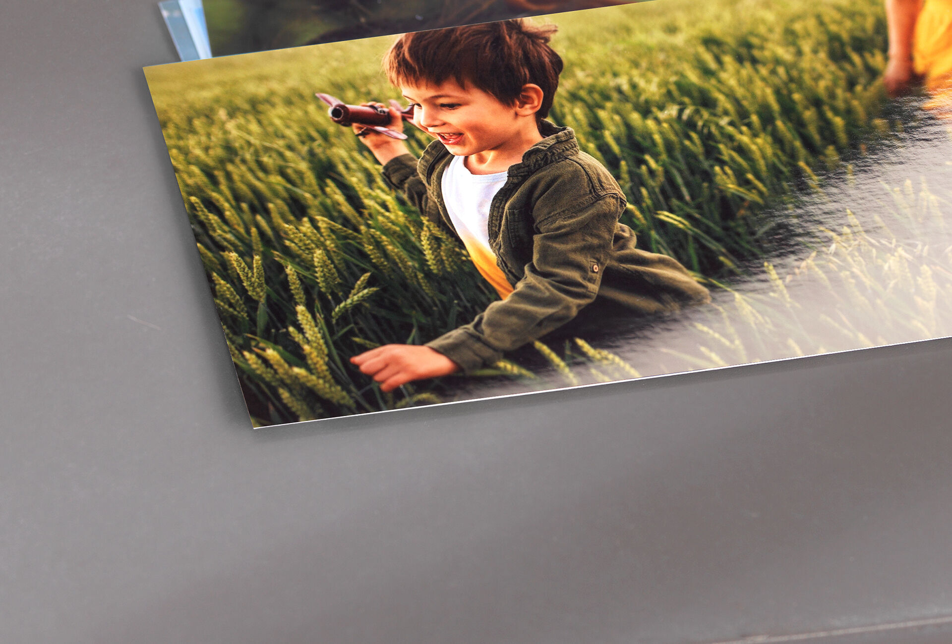 Een kind in een veld op zoek naar iets met een speelgoedcamera