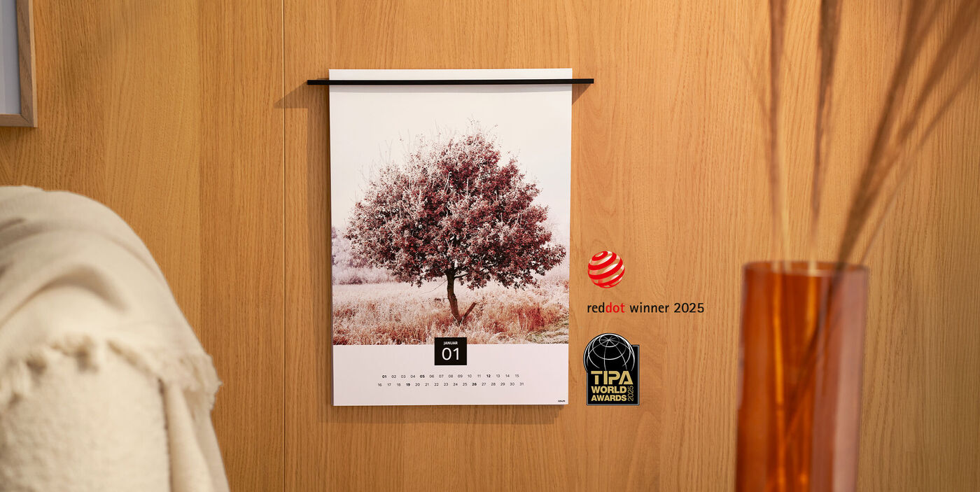 Een CEWE Fineline kalender aan de wand met een foto van een boom