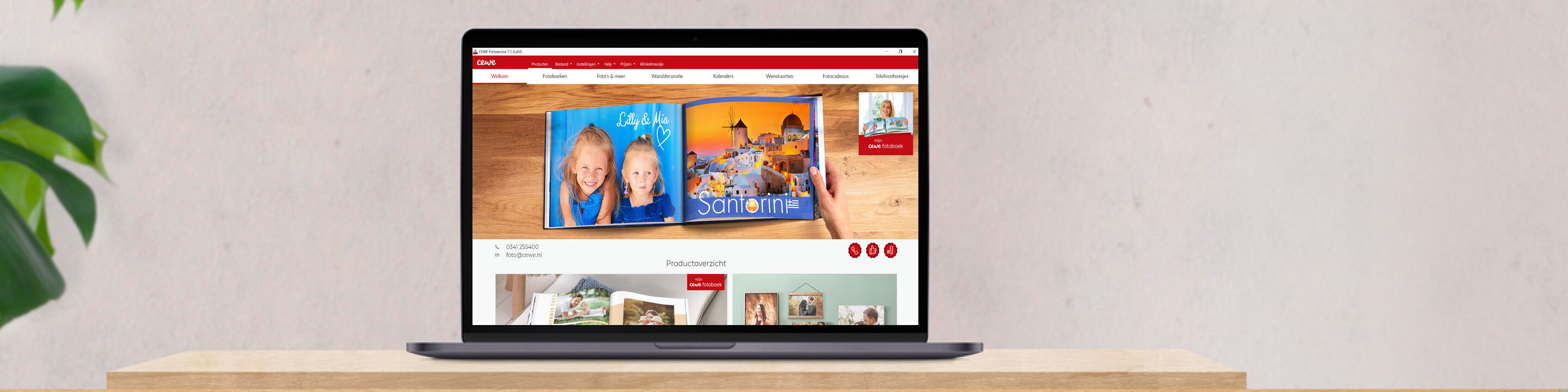 Een laptop toont de website van CEWE met twee kinderen die door een fotoboek bladeren
