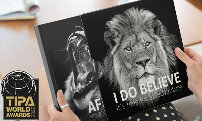 Deux livres photo avec des lions, tenus par une personne, mettant en avant 'I DO BELIEVE'.