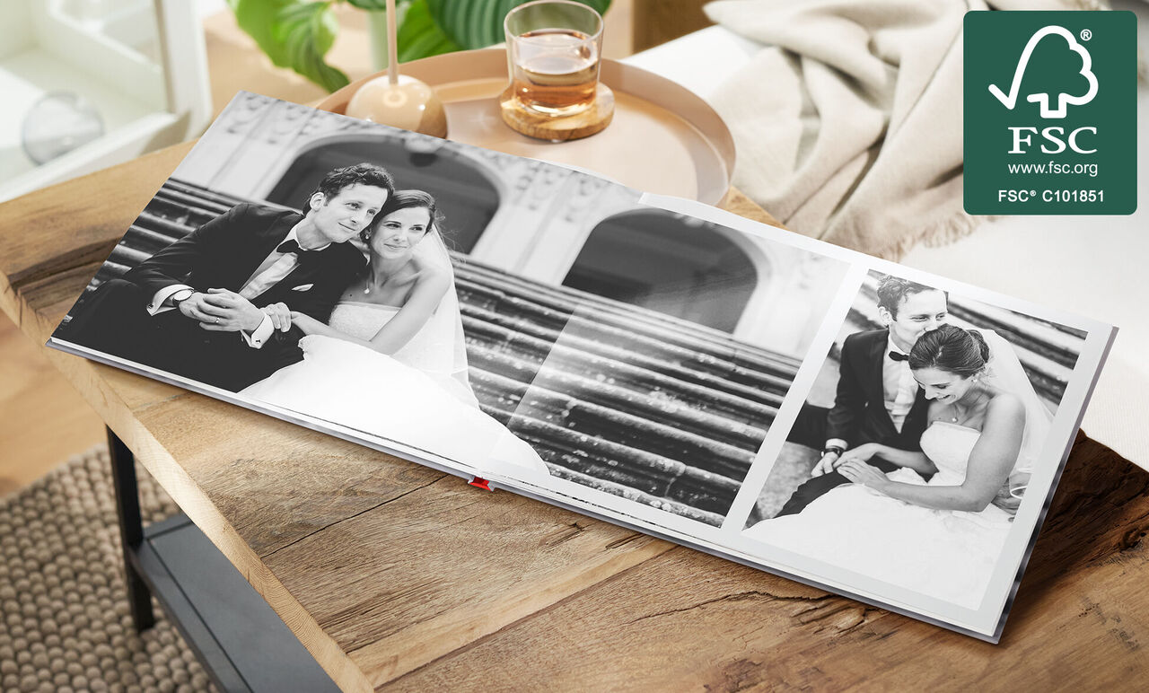Un album photo ouvert avec des photos de mariage sur une table. Les images montrent un couple élégant.
