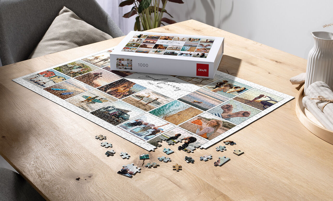 Un puzzle de 1000 pièces avec de nombreuses images sur une table en bois, certaines pièces sont à côté.