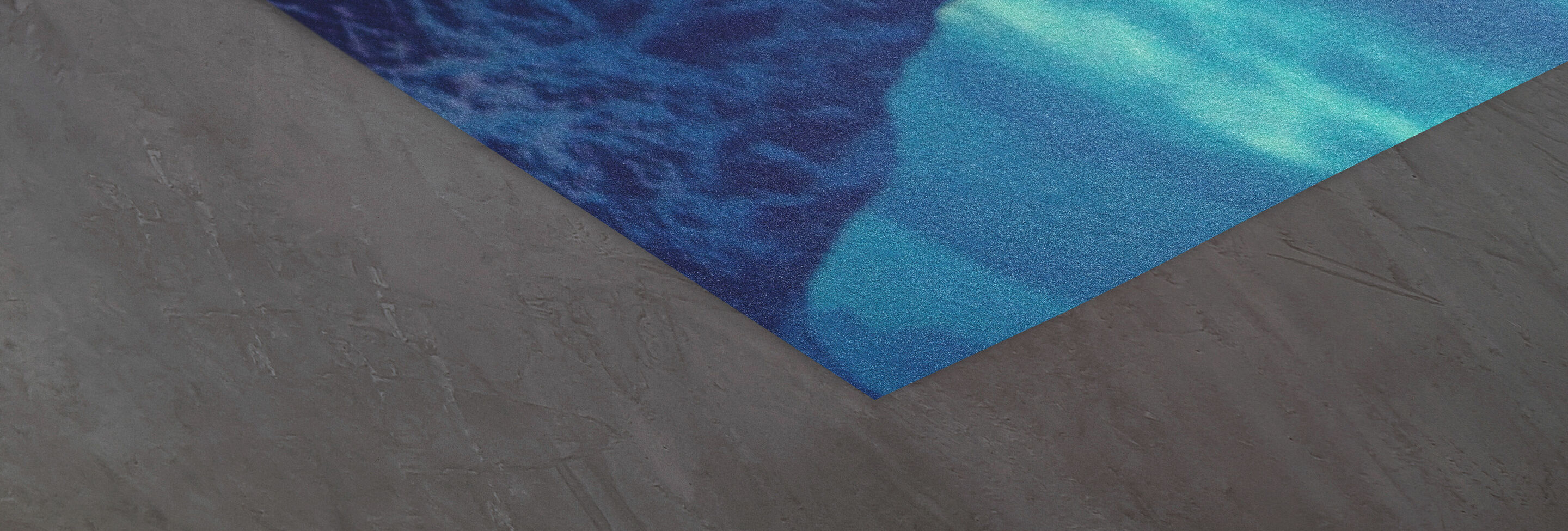 Détail d'un coin textile bleu à motif sur fond gris