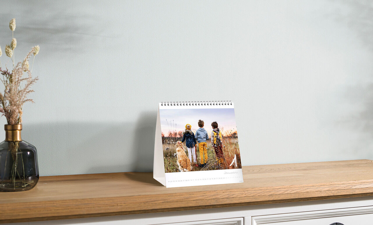 Trois personnes se tiennent dans un champ en regardant le coucher de soleil, entourées par la nature.