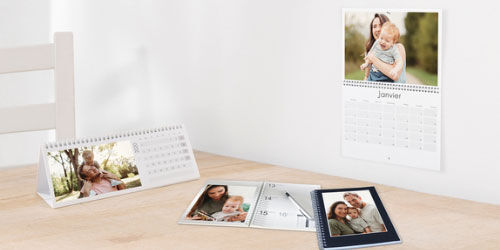 Deux calendriers photo personnalisés avec des photos de famille sur une table.