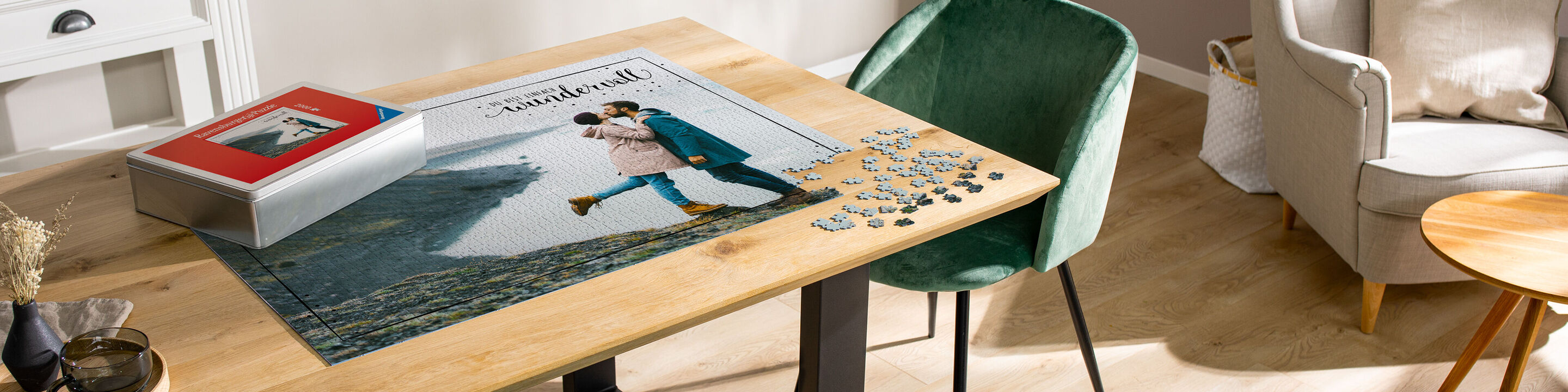 Un album photo CEWE sur un bureau en bois moderne et joliment décoré avec des pièces de puzzle.