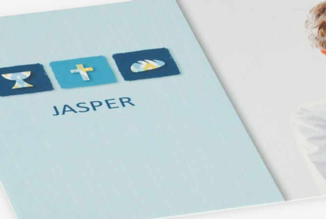 Personne tenant un CEWE livre photo avec le nom Jasper et des symboles