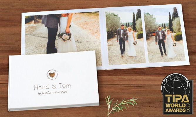 Un magnifique livre photo d'Anna et Tom, illustrant leur mariage, accompagné du trophée TIPA World Awards 2020.