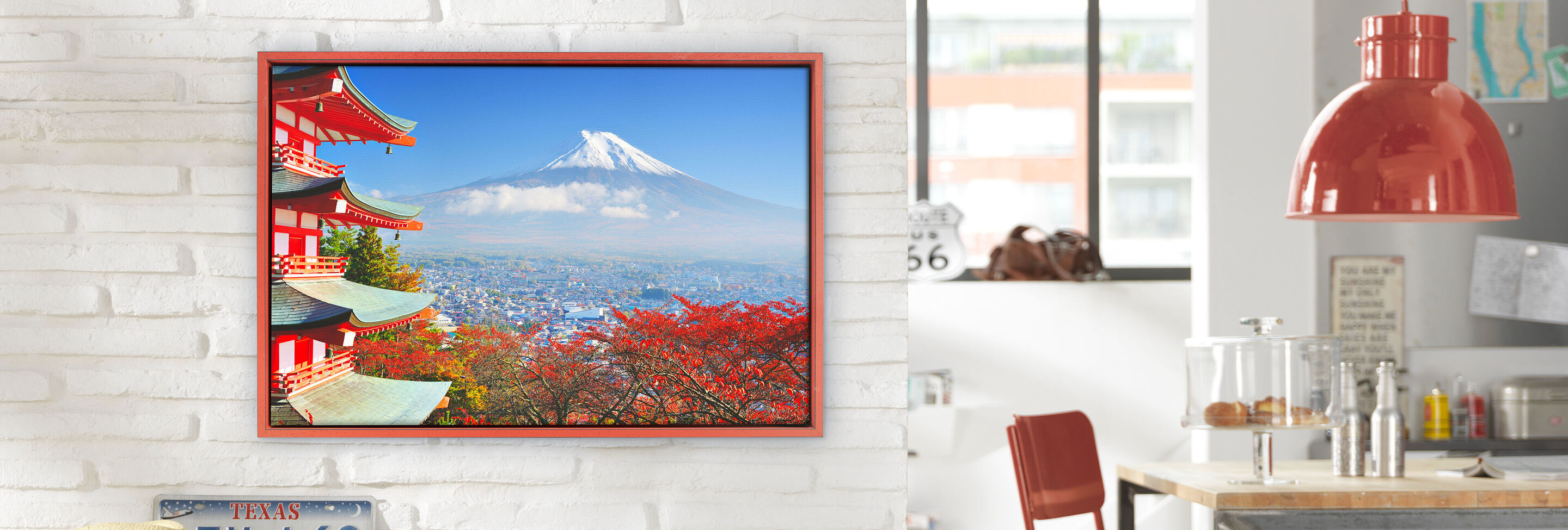 Une magnifique image avec le Mont Fuji et des feuilles d'automne rouges accrochée dans le salon.