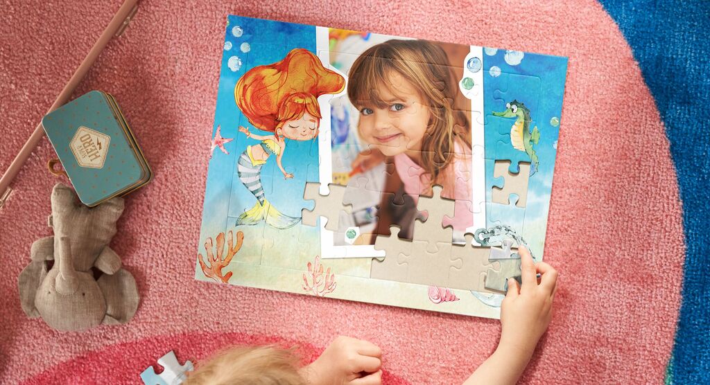 Un enfant assemble un puzzle avec un motif sous-marin soigneusement conçu, entouré de détails colorés.