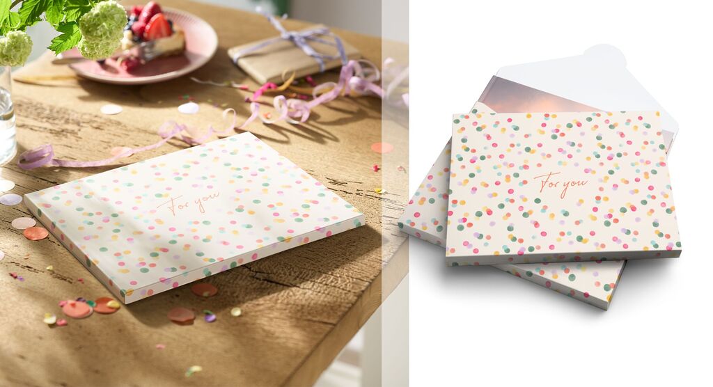 Deux cartes de vœux joyeuses avec des points colorés sur une table en bois, décorées de confettis et d'une déco ludique.