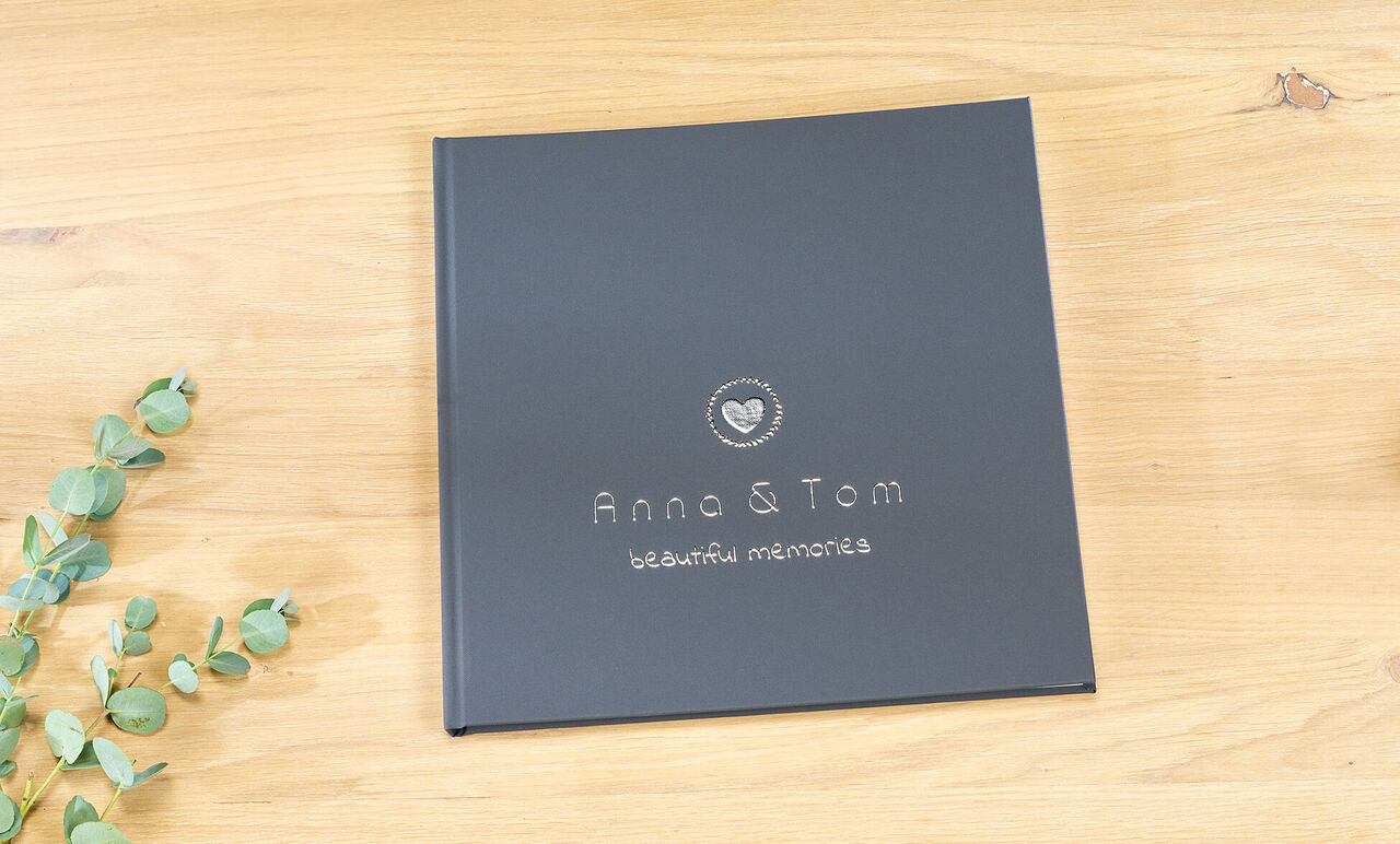 Livre photo noir intitulé 'Anna & Tom' sur une table