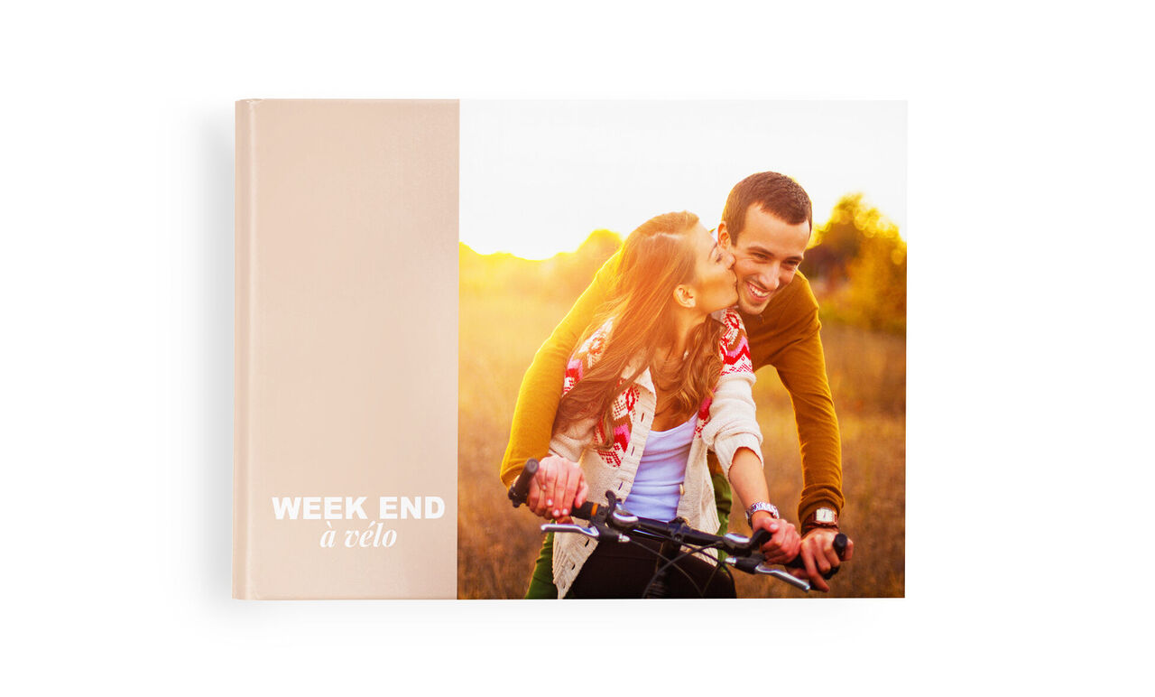 Un homme et une femme profitent d'un moment romantique au coucher du soleil sur un vélo. C'est un CEWE PHOTOBOOK de leurs souvenirs.