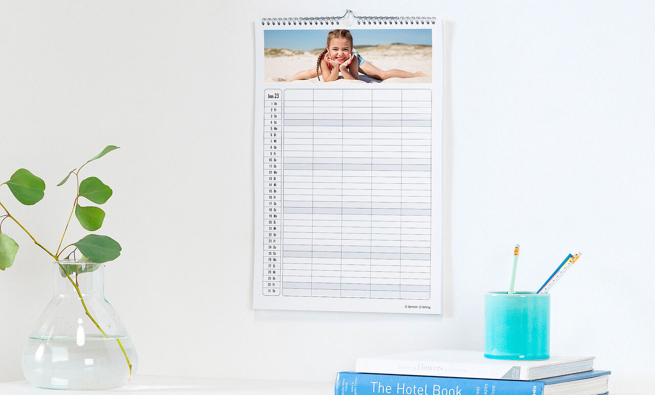 Un joli calendrier photo au mur avec une image de plage et un calendrier clair.