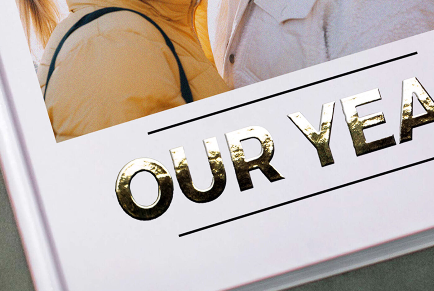 Gros plan sur la couverture d’un livre photo avec les lettres dorées à chaud « OUR YEAR ».