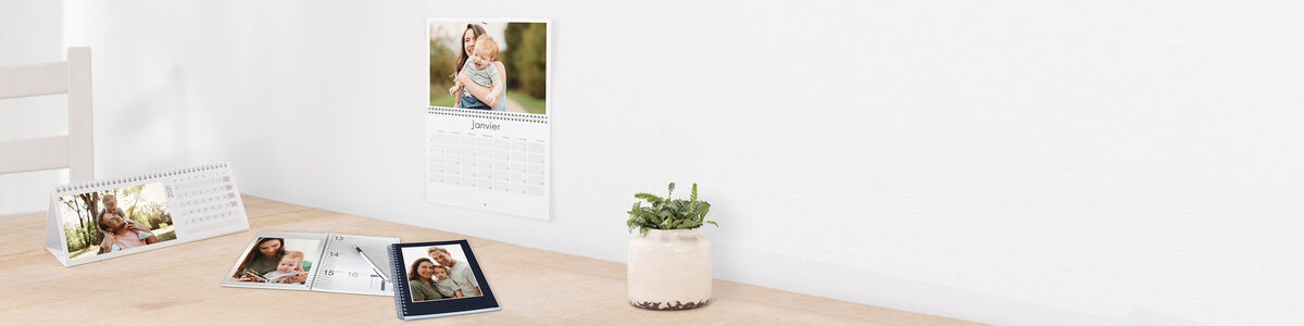 Une table avec un calendrier et différentes photos disposées de manière élégante.