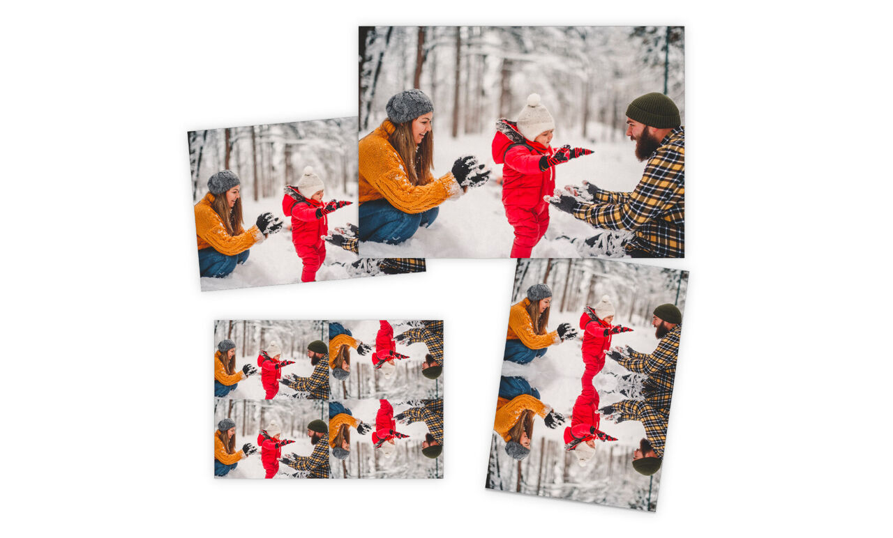 Une famille heureuse joue dans la neige. Les parents lancent de la neige à leur enfant riant en combinaison rouge. Tout est entouré d'arbres blancs.