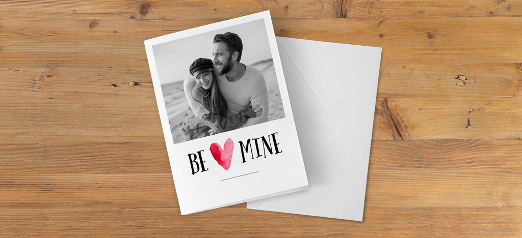 Un design romantique de carte de vœux avec l'inscription "BE MINE" et un couple sur le devant.