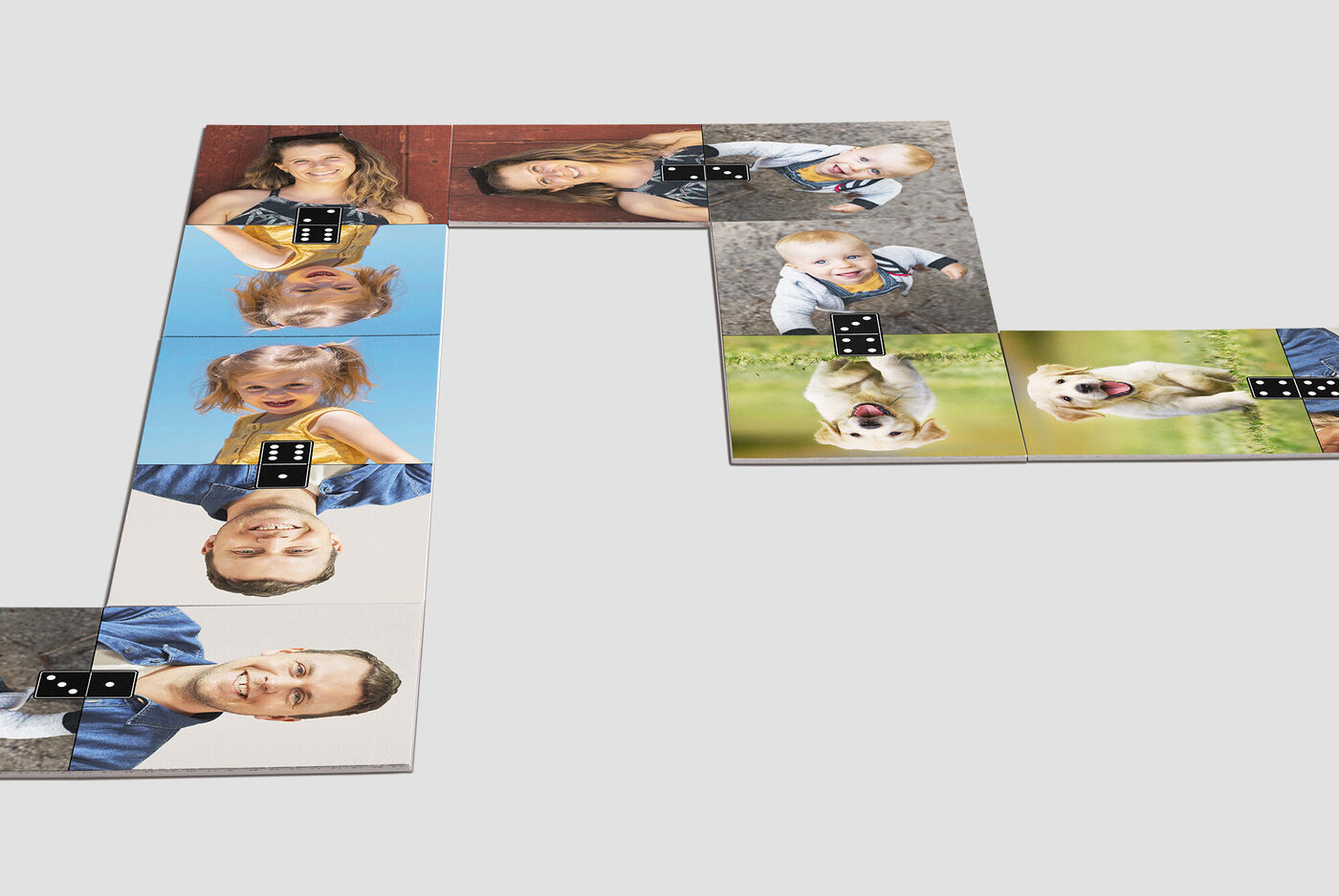 Un agencement créatif de cubes photo avec des visages joyeux et un chien. Les cubes racontent des moments heureux.